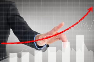 composite of businessman pointing at rising graph